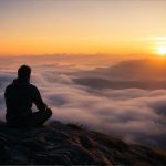Eine einzelne Person steht still in einer weiten Naturlandschaft bei Sonnenaufgang. Nebel liegt über dem Tal, während sanftes Licht die Szene durchdringt und eine Atmosphäre von innerer Ruhe, Selbstreflexion und spiritueller Tiefe vermittelt.